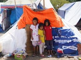 Children in front of their tent made using one of Plans shelter kits