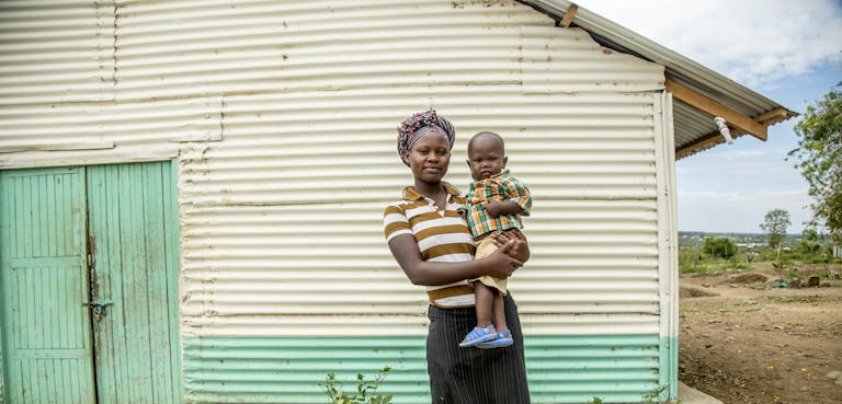tienermoeder en haar kind voor hun huis in kenia