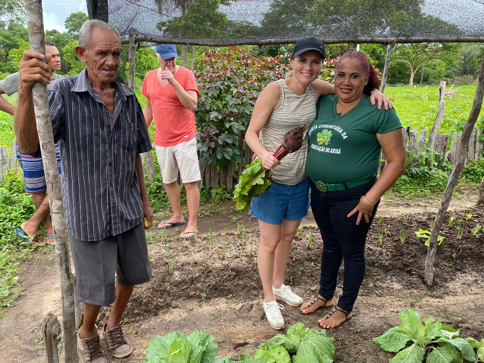 Sarina met een paar werkers in de tuin.