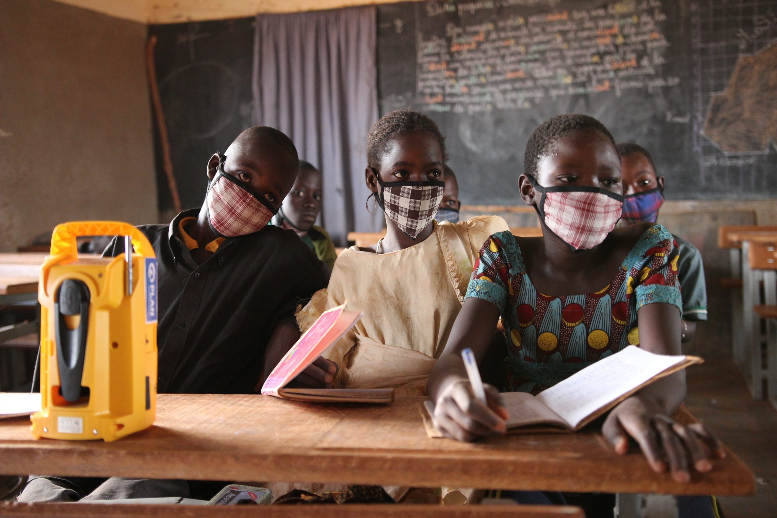 kinderen in de schoolbank met een radio in Burkina Faso