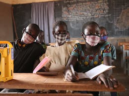 kinderen in de schoolbank met een radio in Burkina Faso