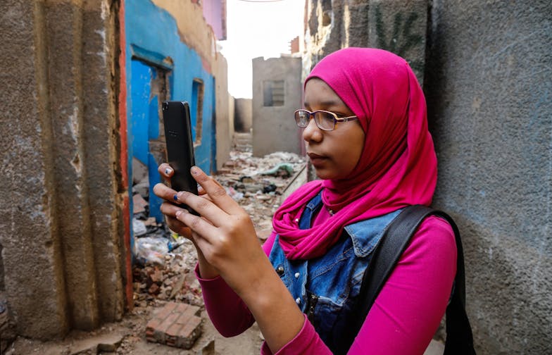 Meisjes in gesprek met social media platforms over online intimidatie meisje met roze kleding en bril op haar telefoon Girls Get Equal