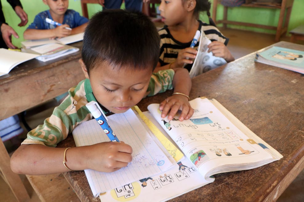 Don (6 jaar) schrijft het woord ‘water’ in het Lao