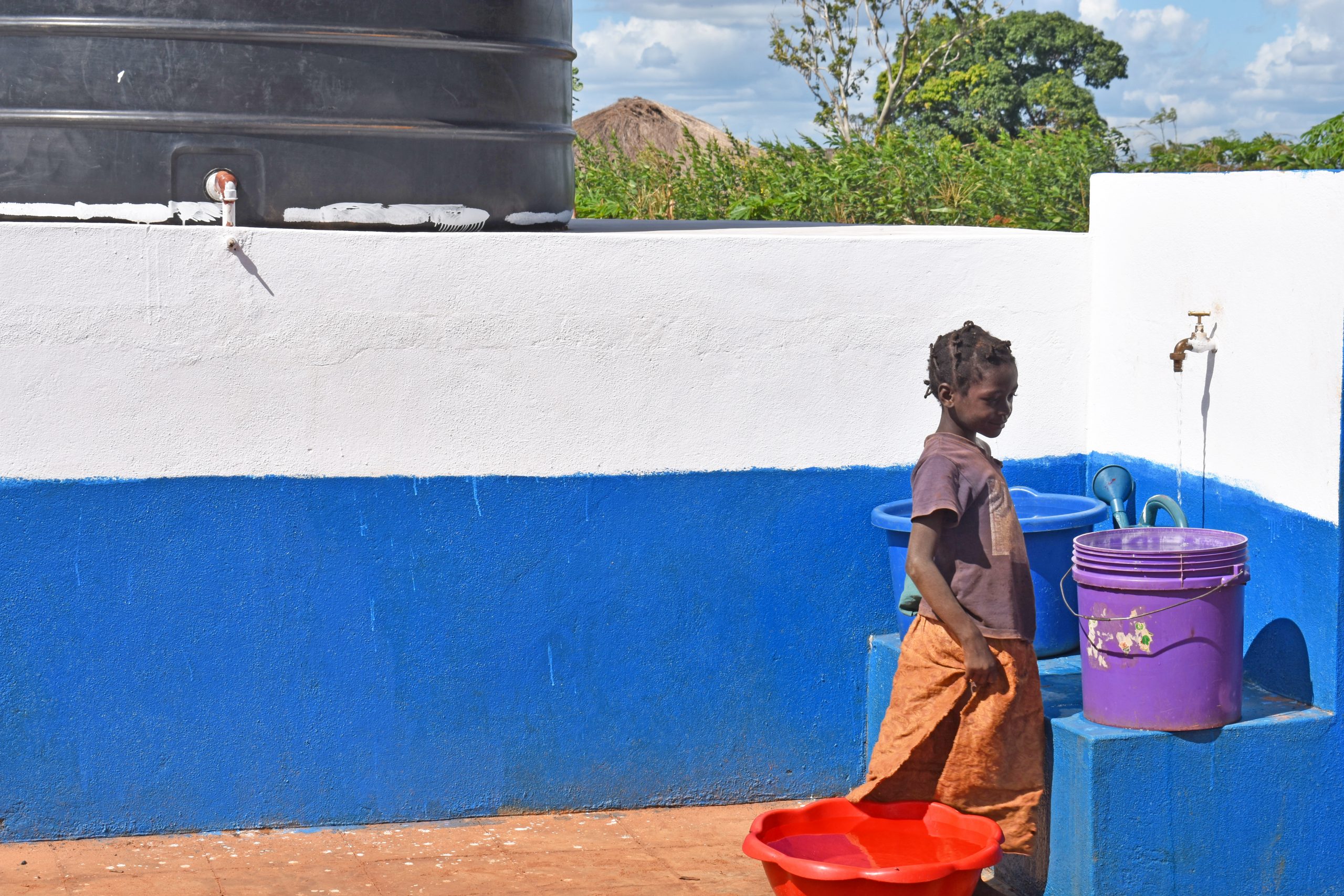 Meisje gebruikt waterpunt van Plan International in Cabo Delgado