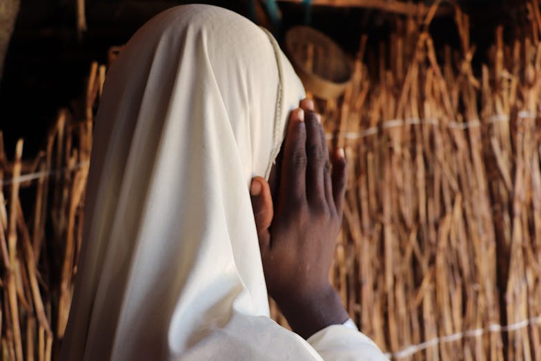 Meisje schermt haar gezicht af van de camera