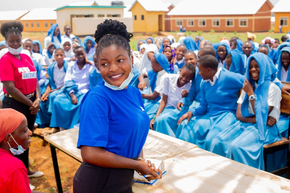 Wereldmeisjesdag evenement in Tanzania jonge vrouw lacht met groep meiden