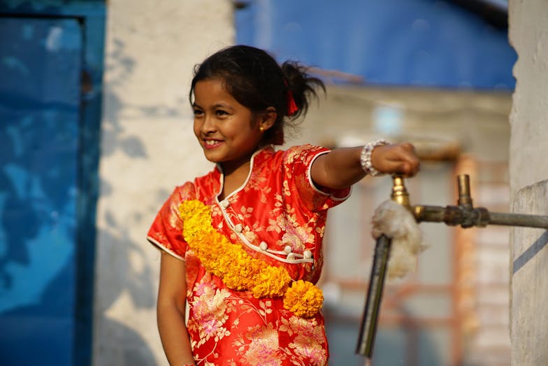 meisje in Nepal meisje draait kraan dicht in Nepal