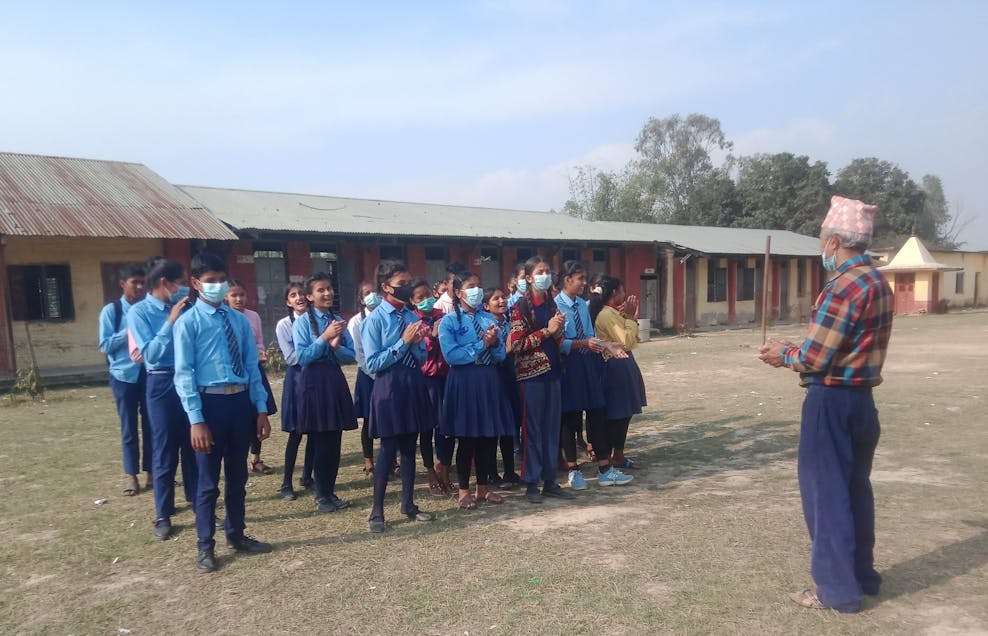 training in Nepal kinderen krijgen voorlichting op het schoolplein