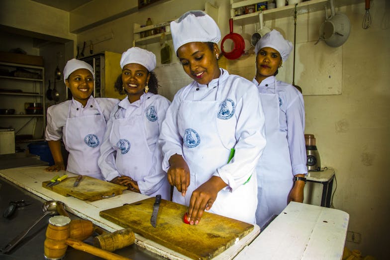 jonge vrouwen in koksuniform krijgen training