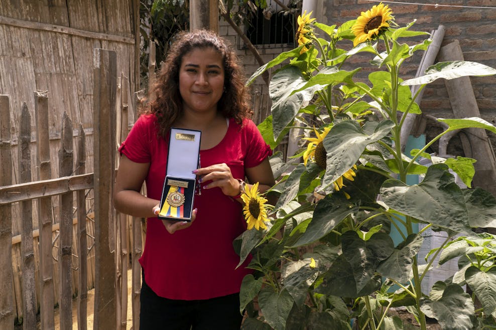 Sandra Valeria, 23, laat haar medaille zien die ze kreeg voor spreken in het openbaar