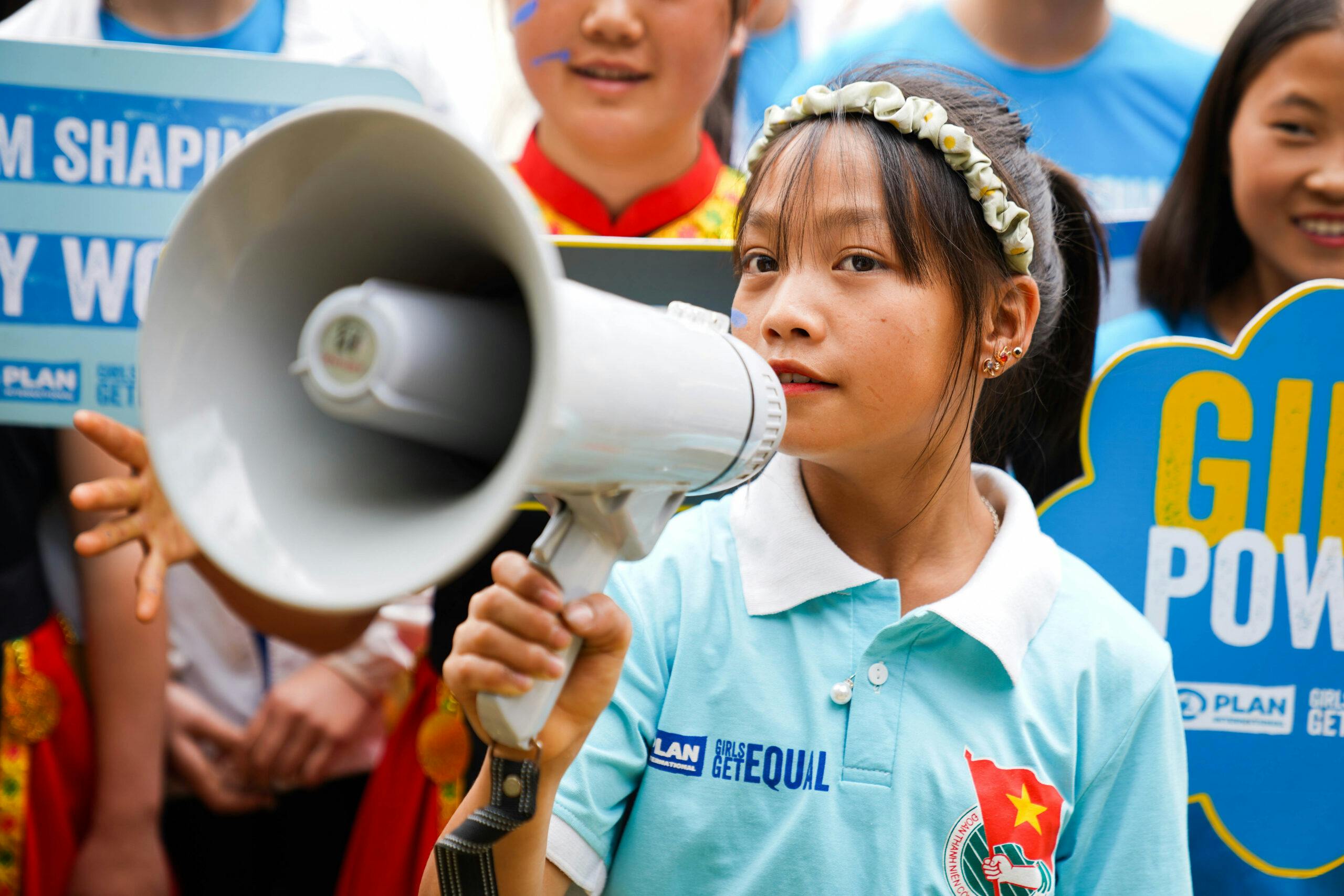 Vietnamees meisje met een megafoon kijkt in de camera