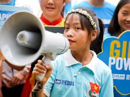 Vietnamees meisje met een megafoon kijkt in de camera