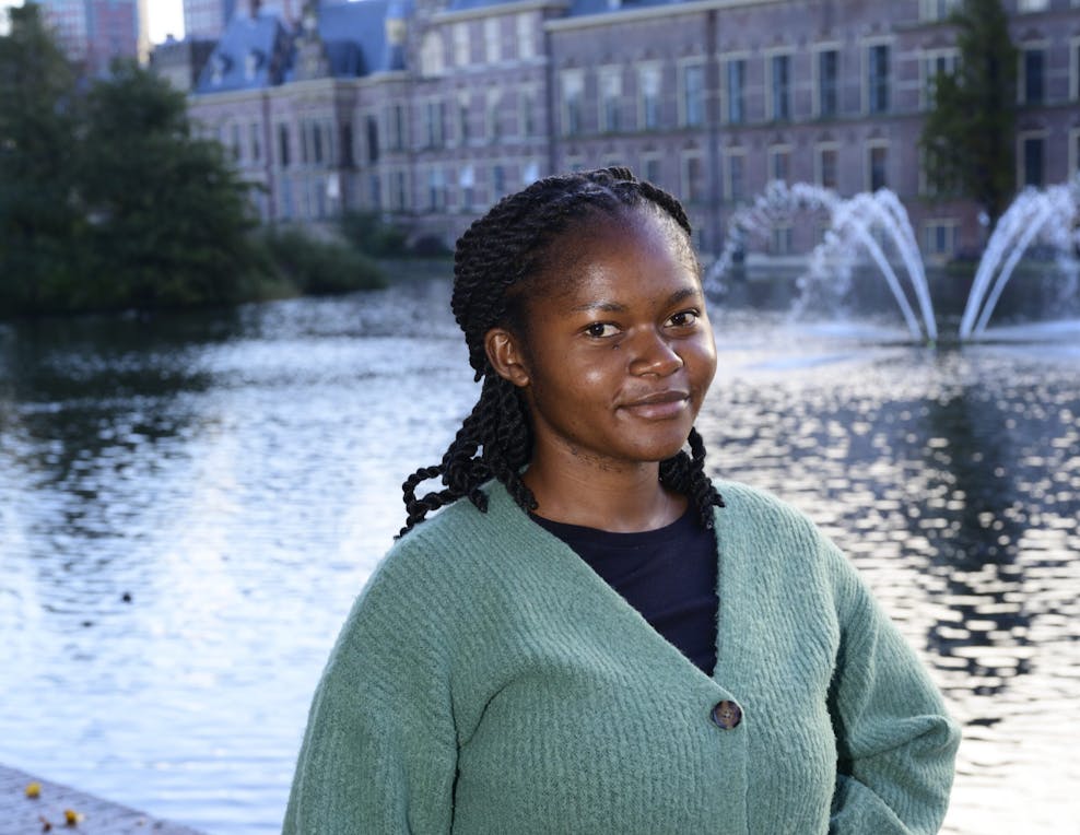 “Iedereen zou vrijuit moeten kunnen praten over seksuele gezondheid” Een meisje in een mintgroen vest staat voor de Hofvijver in Den Haag.