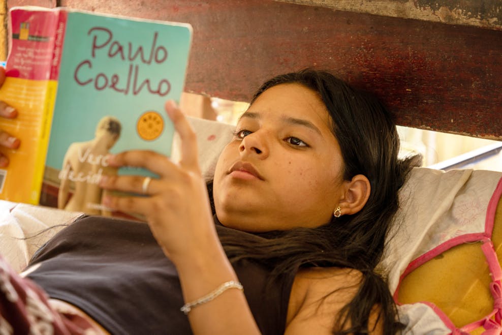 Carmen moest alles achterlaten: “Voor meisjes is vluchten extra gevaarlijk” Carmen (16) ligt op haar bed en leest een boek van Paulo Coelho.