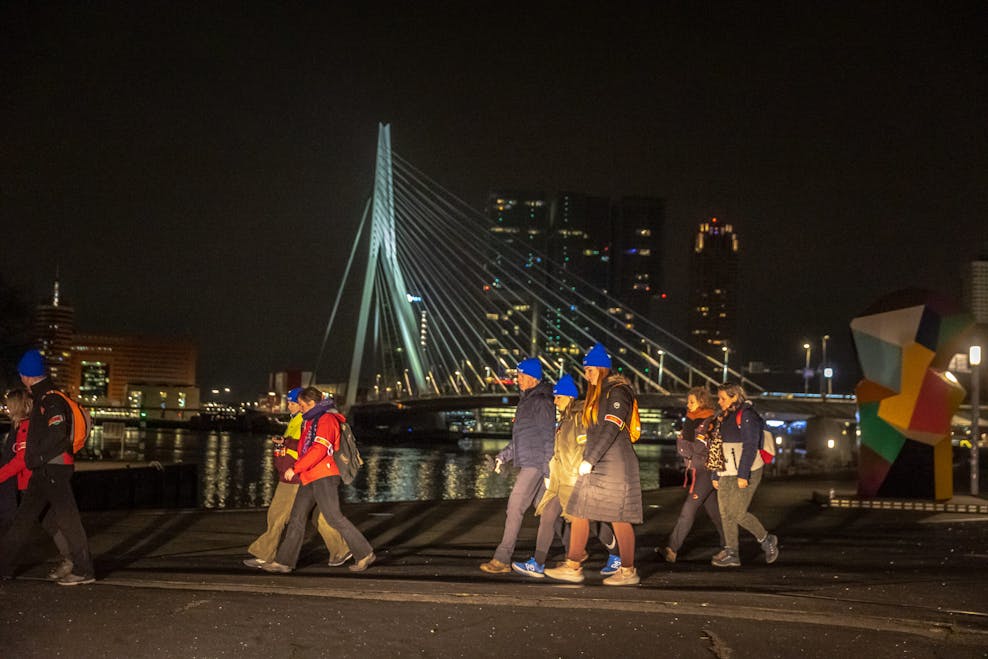 Deelnemers aan de Nacht Tegen Seksueel Geweld lopen langs de Erasmusbrug in Rotterdam.
