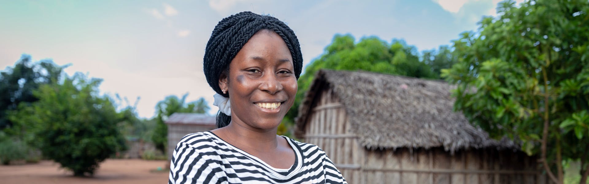 Helena kijkt lachend in de camera. Ze heeft haar armen over elkaar en draagt een zwart-wit gestreept t-shirt.