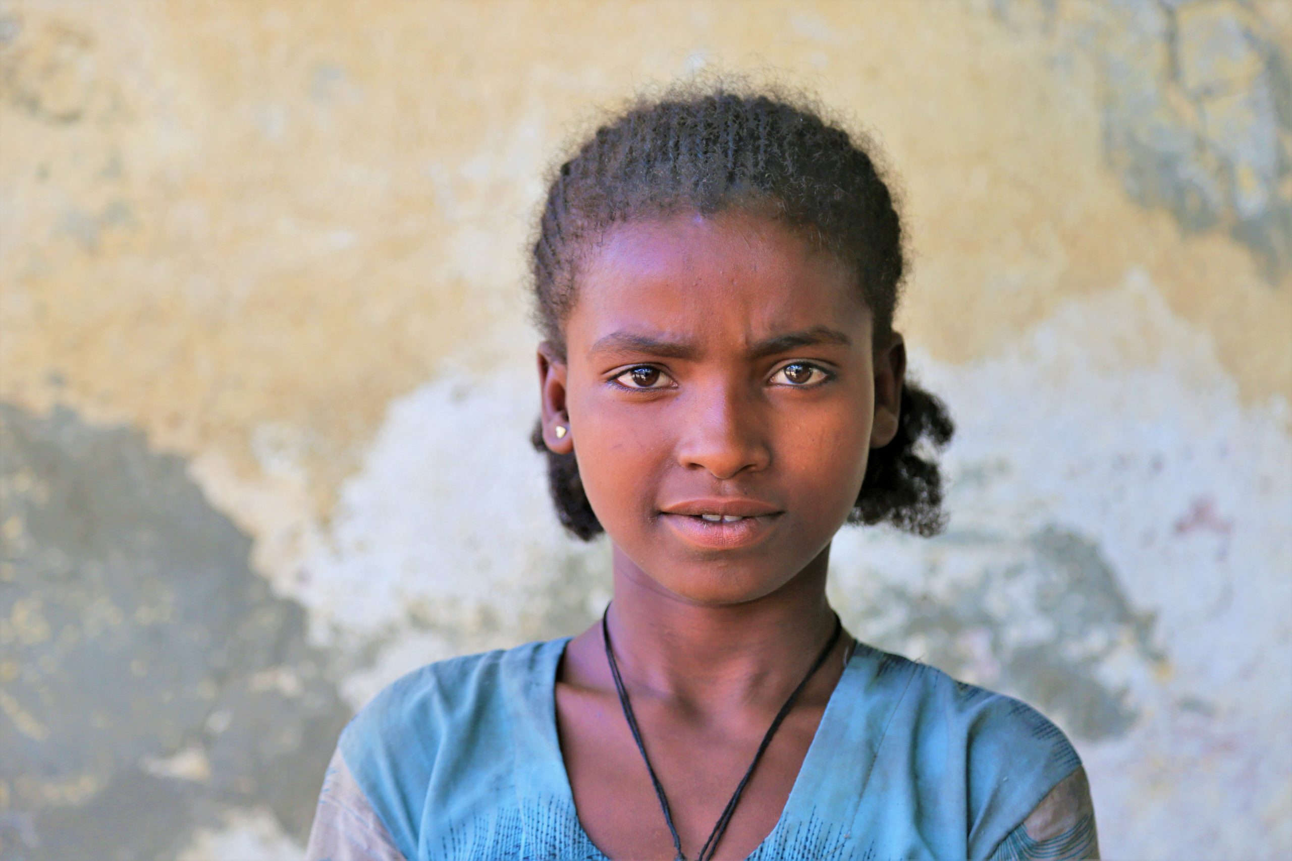 Meisje uit Ethiopie kijkt recht de camera in.