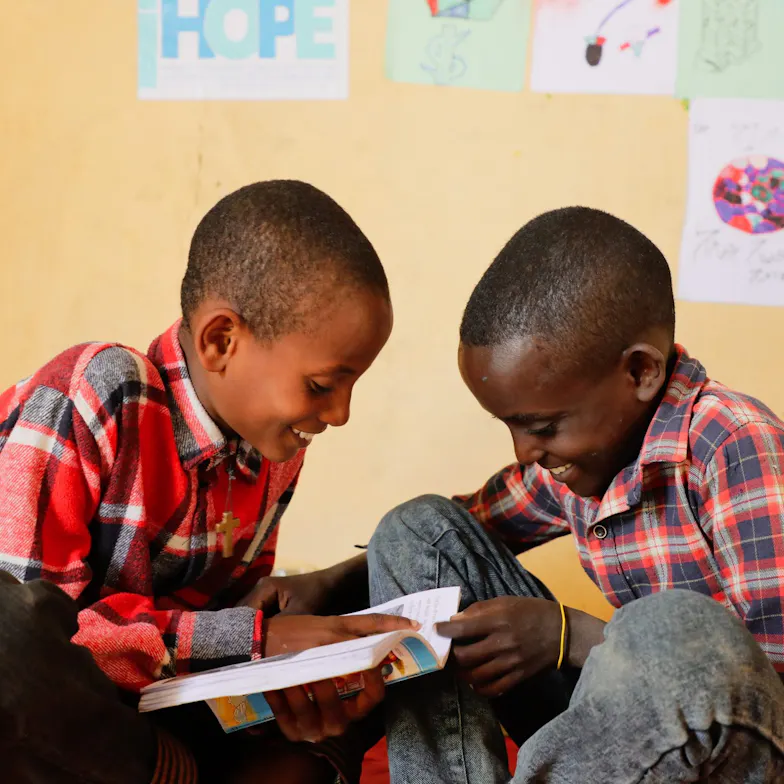 Twee vorlijke jongens lezen samen.