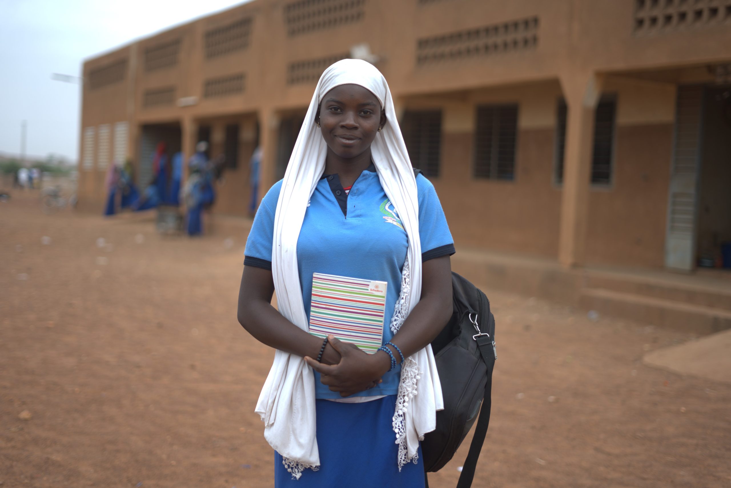 Meisje in burkina Faso voor schoolgebouw
