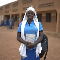 Meisje in burkina Faso voor schoolgebouw